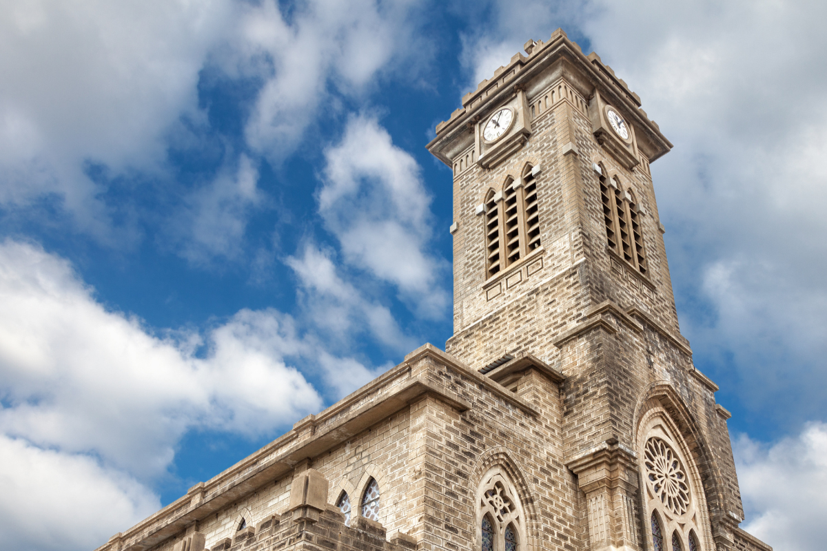 Nha Trang Cathedral bell tower with large four-faced clock and bronze bells